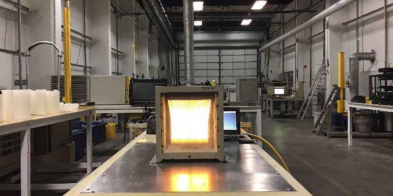 A laboratory spectrometer analyzing an aluminum ingot to verify its chemical composition.