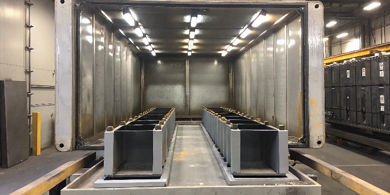 Coated die-cast parts mounted in a salt spray corrosion test chamber.
