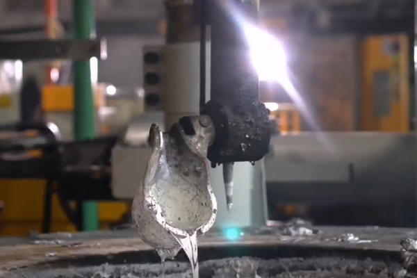 A close-up shot of a high-tech die-casting machine in operation, with molten aluminum and precision molds.