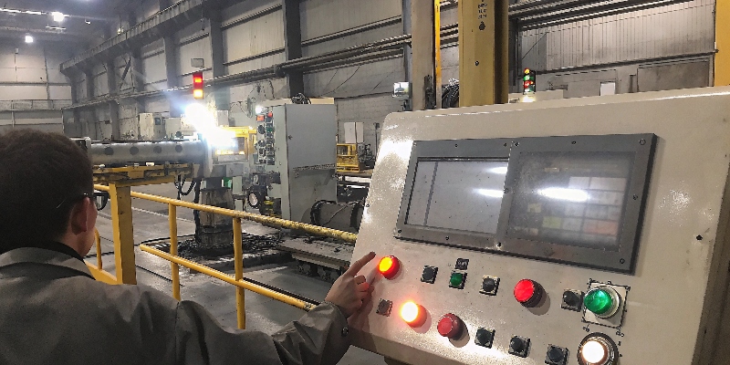 A die casting machine operator checking parameters on the control screen