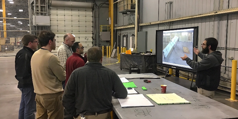 A team of OEM and supplier engineers collaborating over a 3D model in a meeting