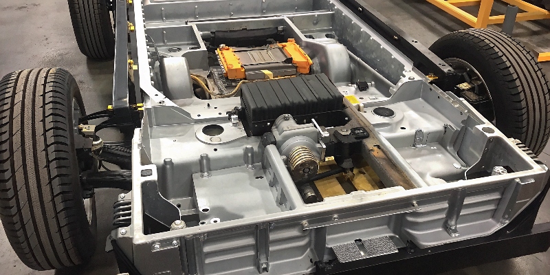 An exploded view of an electric vehicle powertrain showing various die-cast aluminum components