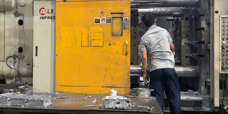 A die-casting machine in action, injecting molten aluminum into a mold to form a complex EV component.