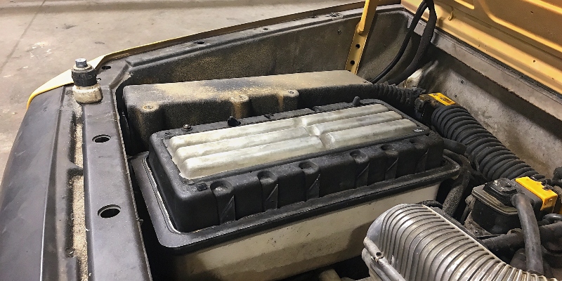 Ein Bauteil aus ADC12 in einem Motorraum, das trotz Schmutz und Hitze intakt aussieht