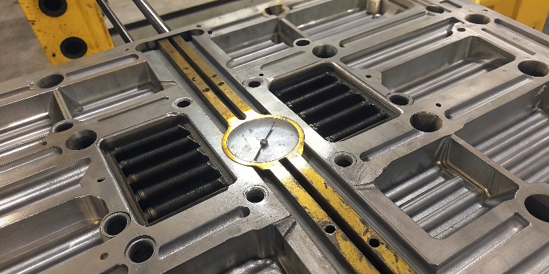 Eine Nahaufnahme einer Messuhr, die eine enge Toleranz an einem komplexen Aluminiumgussteil prüft