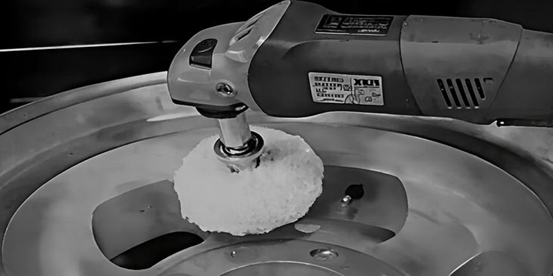 A technician wearing gloves carefully cleaning a corroded aluminum part using a soft brush and a basin of cleaning solution.