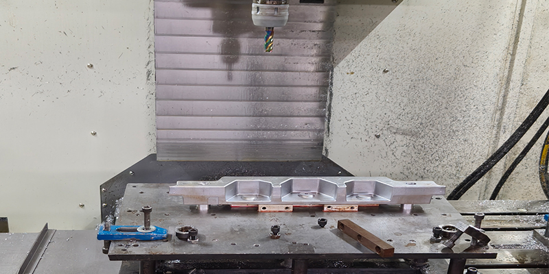 Overview of Common Machining Processes for Aluminum Castings A CNC milling machine with a multi-tool carousel working on an aluminum die-cast housing.