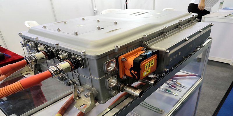 A bare aluminum die-cast EV battery tray being lifted, emphasizing its large but lightweight structure.
