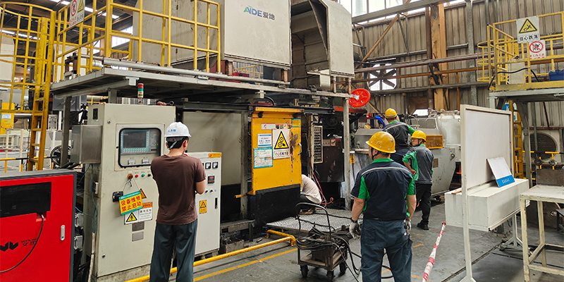 A visual representation of EMP Tech's integrated approach: project manager, CAD designer, simulation engineer, and mold maker collaborating around a digital model of an EV motor housing mold.